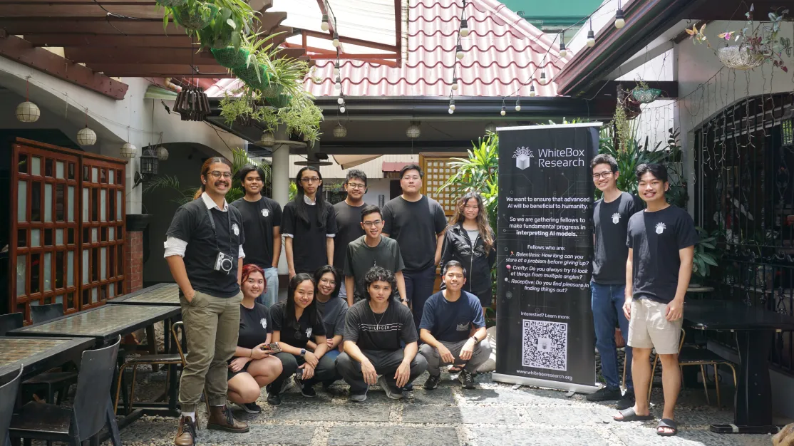 The 2025 WhiteBox Research cohort gathered beside a WhiteBox banner